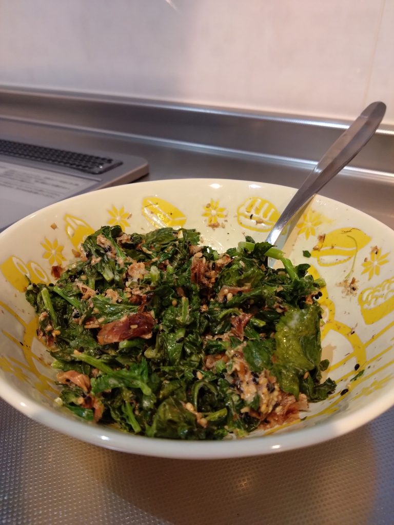 黄色のお皿に大根の葉っぱのおかずが入っている