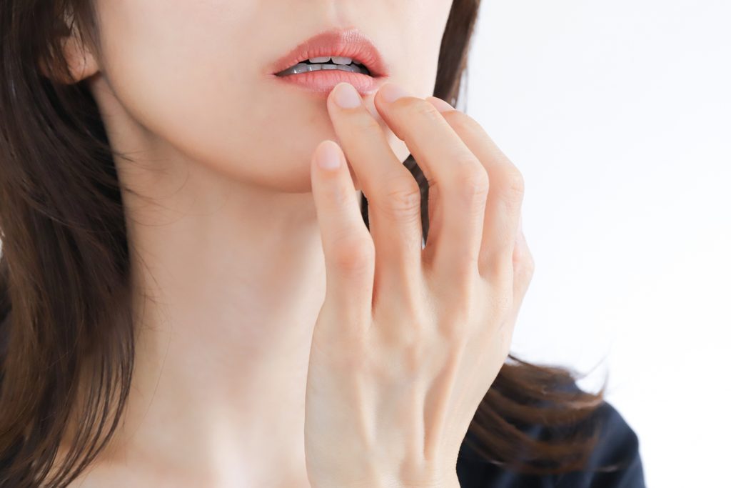 唇を指で触っている女性
